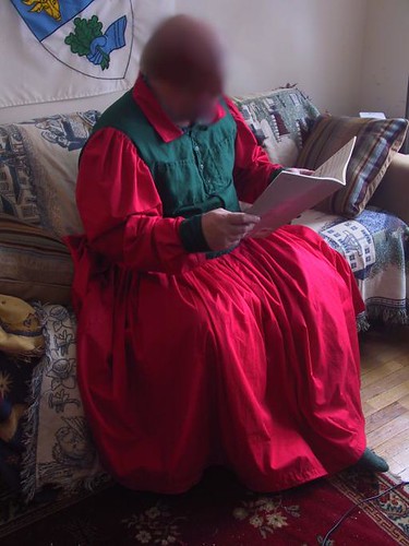 "man in red dress, seated"